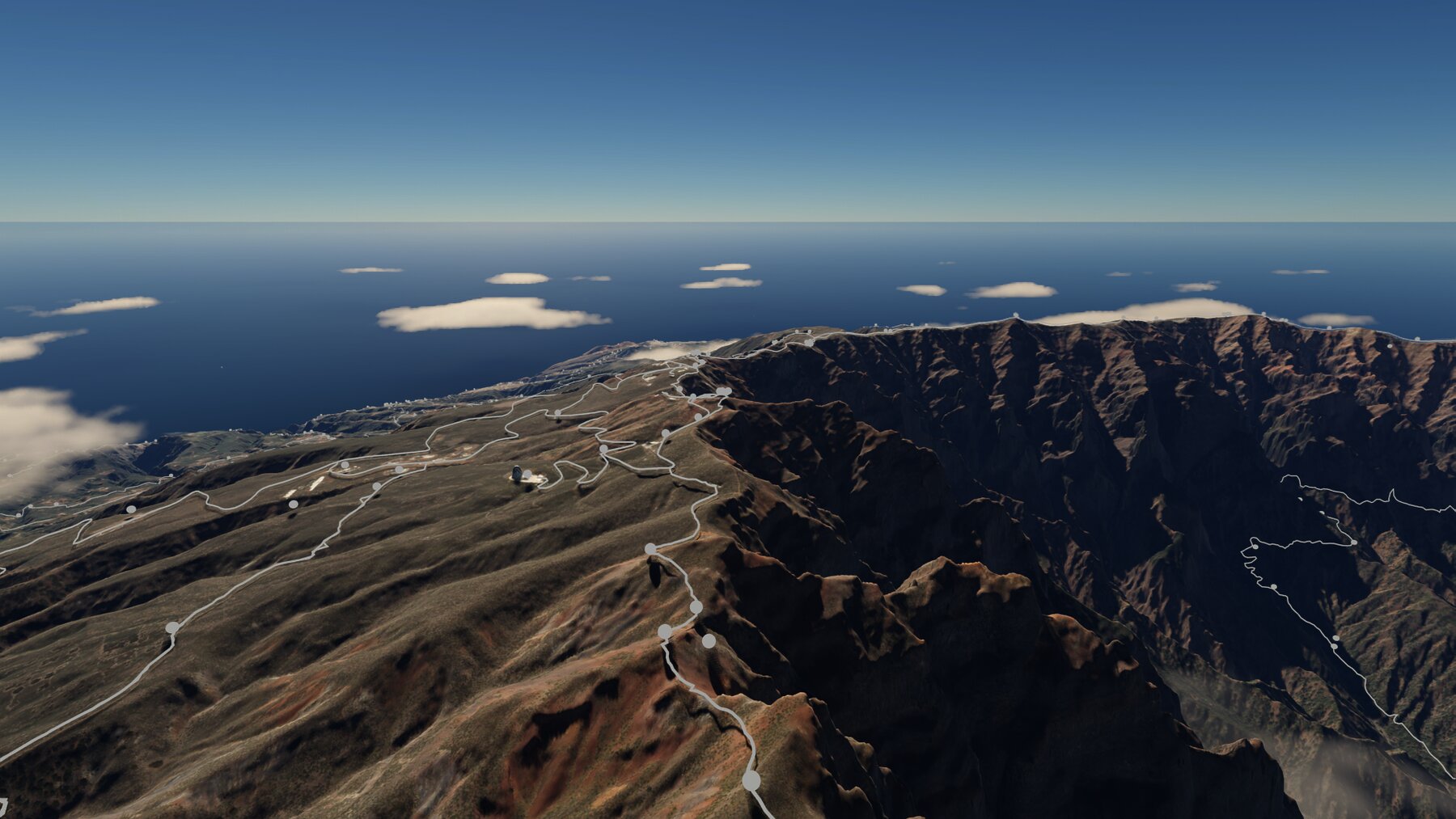 La cresta de la cumbre desde el aire, con las cúpulas del observatorio del Roque de los Muchachos recortadas contra el cielo y los puntos de interés de la red de senderos marcados a lo largo del filo.